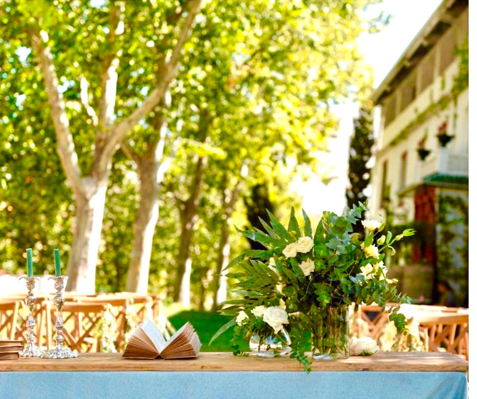 Mesa de ceremonia con flores blancas bajo los árboles